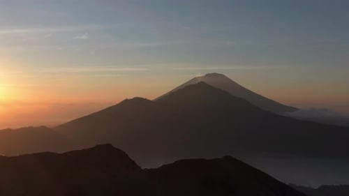 Spectacular mountain landscape with landmark volcanos in Bali during sunrise, aerial