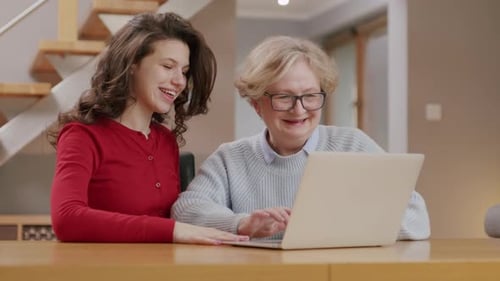 Young Woman Helping Senior Woman with Computer