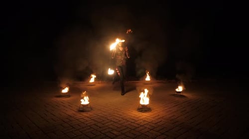A Professional Artist Demonstrates Various Fire Tricks A Fire Show