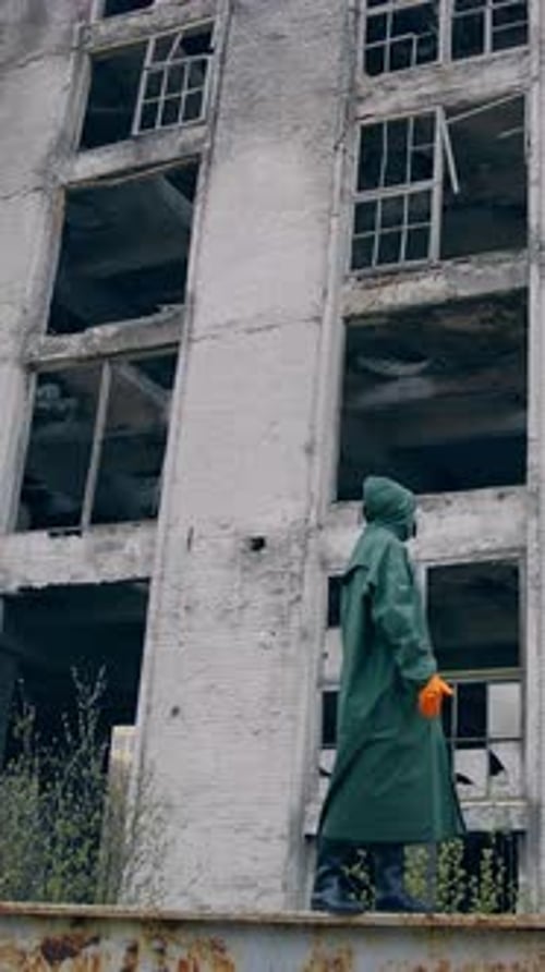 Labortechniker in Maske und Chemikalienschutzanzug beim Gehen