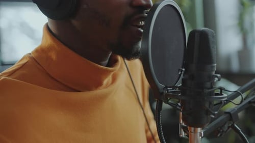 Close-Up of Man Speaking in Microphone as Recording Podcast at Studio