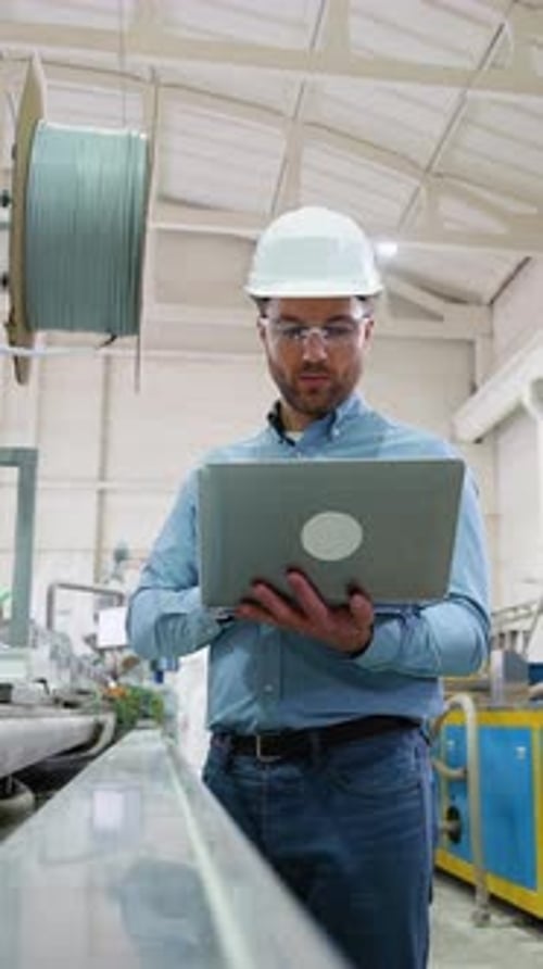 Chief Engineer With Laptop On Factory Analyzes The Production Process Vertical Video
