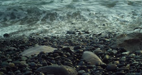 Close Up Shot of the Waves of an Agitated Sea Hitting the Shore Full of Soft