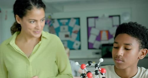 Student and Teacher Studying Molecular Model in Classroom