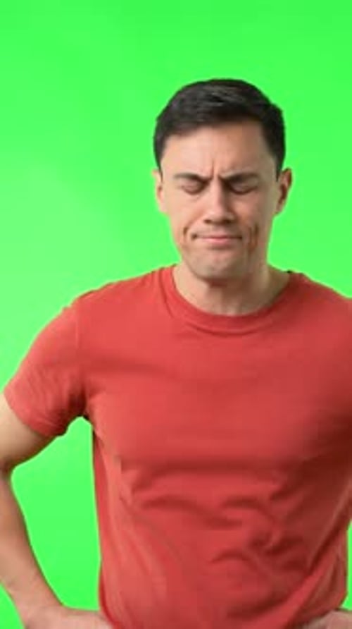 Man Expressing Disapproval with Thumbs Down on Green Screen