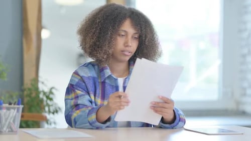 Woman Reviews Documents Indoors During the Daytime
