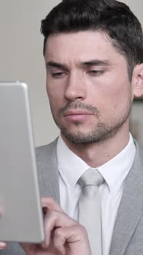 Businessman Browsing and Scrolling on Tablet, Vertical Video