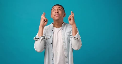 Young Man Wishing With Fingers Crossed Gesture