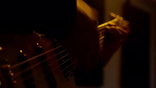 Musician Plays Electric Bass Guitar in Golden Light