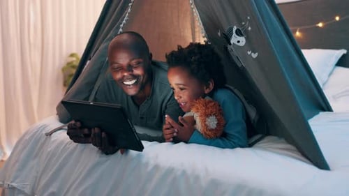 Father and Child Relaxing with Tablet in Tent