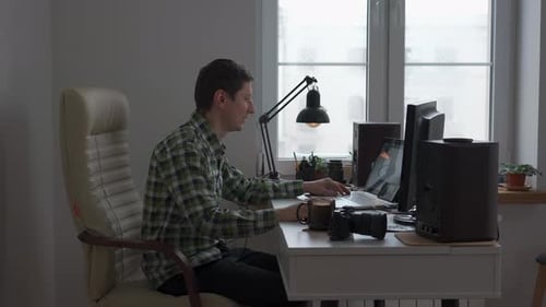 Man Working at Computer in Brightly Lit Room