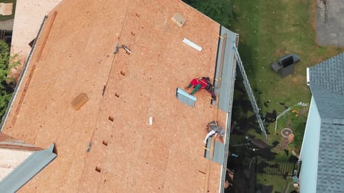 Roofers Installing a New Roof on an Residential Building Aerial Drone Footage