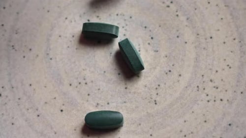 Pills Vitamin Spirulina on Rotating Plate