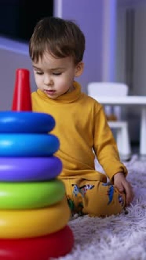 Lindo niño caucásico en pijama amarillo sentado en la esponjosa tela escocesa.