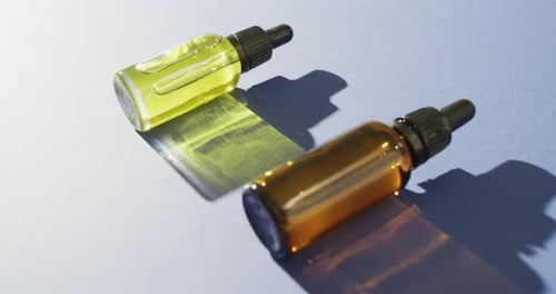 Close up of dropper serum bottles on blue background with copy space
