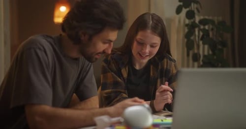 Jeunes adultes collaborant autour d'une table dans un espace de travail familial confortable