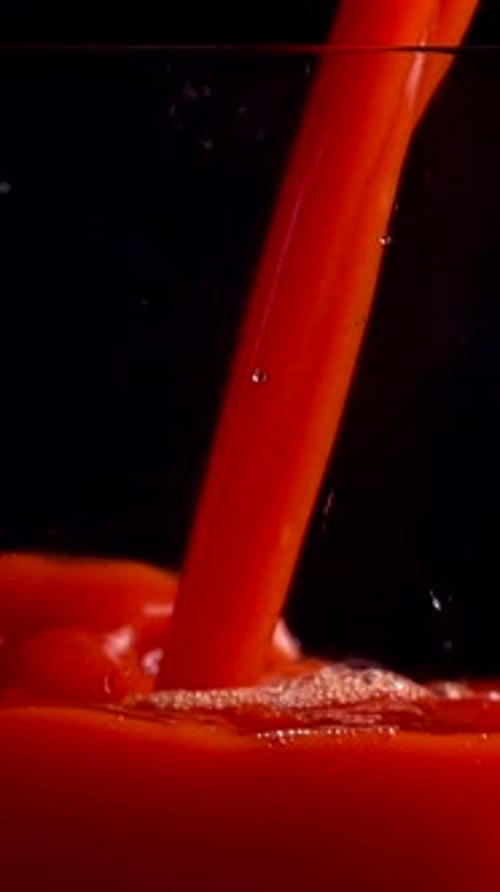 Pouring Red Juice into a Clear Glass
