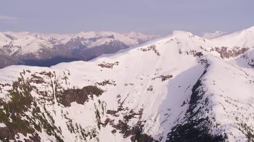 Snowy mountain peaks span the wilderness of british columbia Canada from above