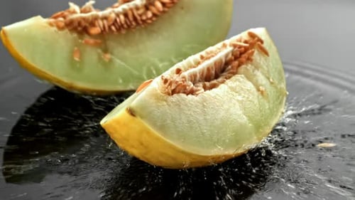 Melonenstücke fallen auf eine nasse Oberfläche, gefilmt mit einer Hochgeschwindigkeitskamera mit 1000 Bildern pro Sekunde