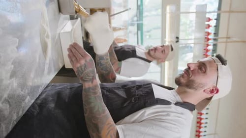 Chef Tossing Pizza Dough in Bright Kitchen