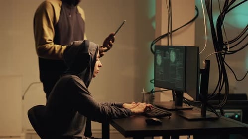 Two Adults Working on Computers in Urban Workplace