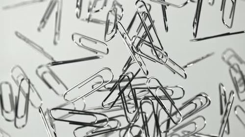 Silver Paper Clips Floating in the Air on White