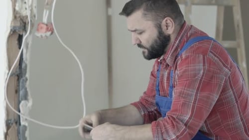 Construction worker comparing color swatches to wall