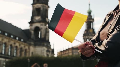 Junge Frau macht Selfie mit deutscher Flagge in der Hand