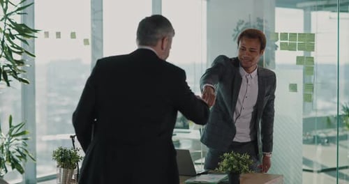 Businessmen Meet in Modern Office, Shake Hands