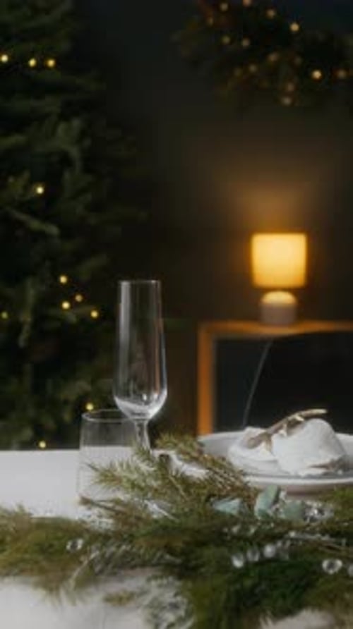 Dinner Table Decorated with Evergreen Garland for Christmas Celebration