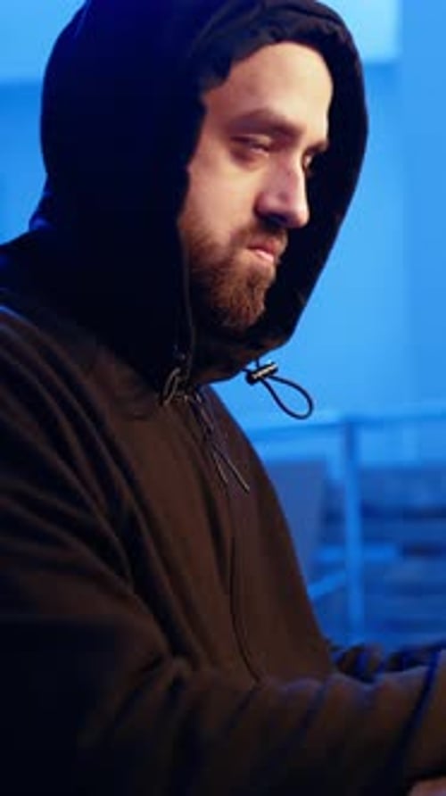 Vertical Video Close Up of Hacker in Graffiti Painted Hideout Focused on Developing Spyware