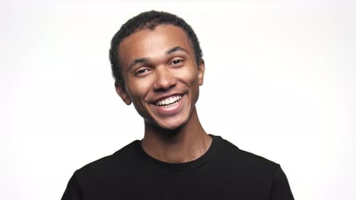 Young Adult Smiling Against White Background Close Up