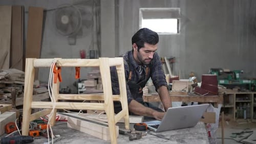 Carpenter is working at workshop.