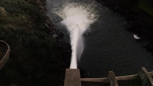 Leistungsstarker Wasserstrahl aus einem Damm — ein Beispiel für hydraulische Infrastruktur