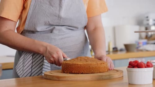 Woman Cuts Layer Cake in Kitchen, Prepares Berries