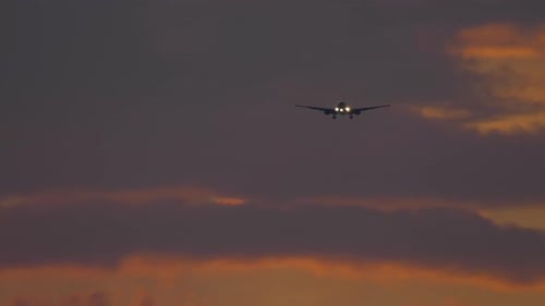 Un avion vole dans un ciel ardent au coucher du soleil