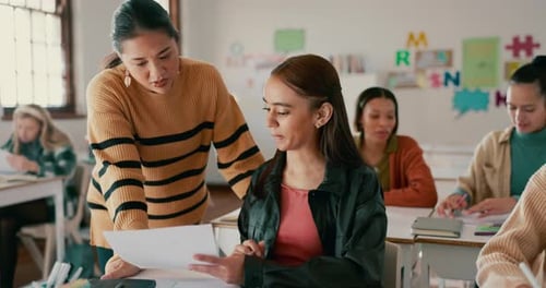 School, education and teacher help student in classroom for learning, check assignment and lesson