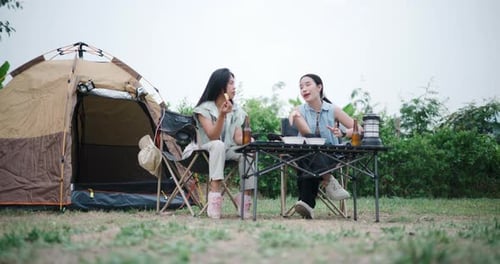 Young Women Camping and Eating Together