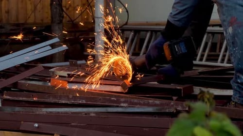 Many Fire Sparks Spreads When A Man Cuts Metal With An Angle Grinder In His Yard