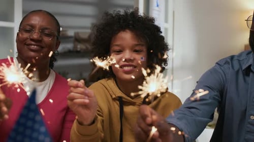 Family Celebrates with Sparklers and American Flags