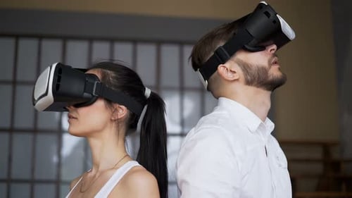 Man and Woman Wearing VR Headsets Indoors