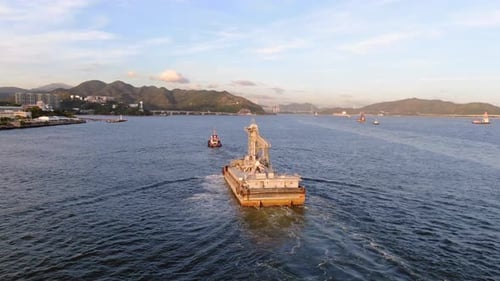 Tugboat pulling a small Barge in Hong Kong bay, Aerial view.