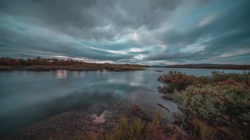 A serene river reflects the sunlit clouds as the beautiful sunset takes over the sky.