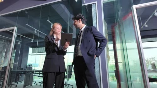 Business meeting in modern office between two professionals discussing documents