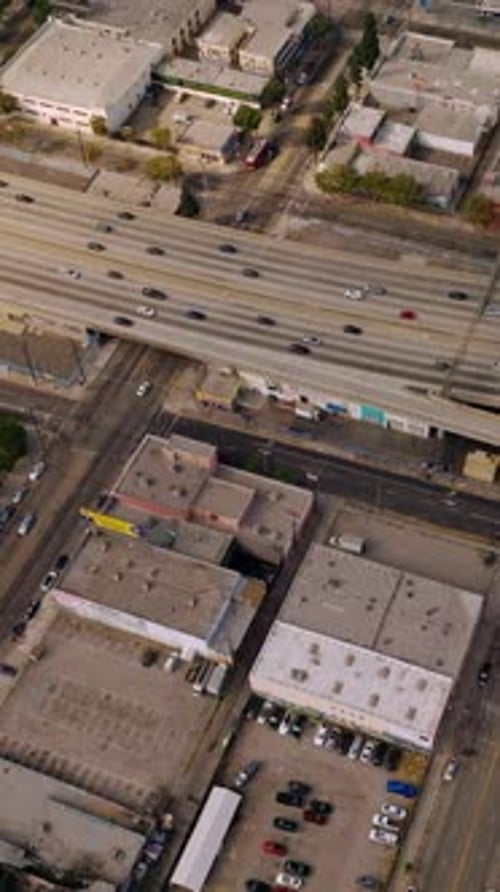 Traffic on the roads of Los Angeles at sunny daytime. Drone footage over the low buildings
