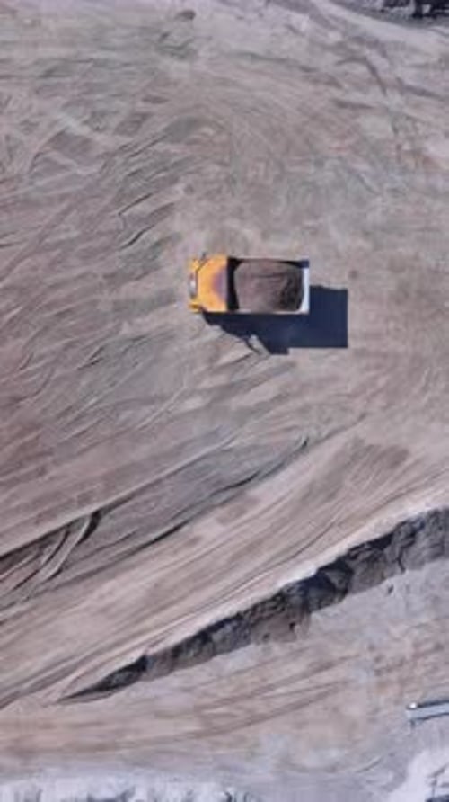 Excavation Activity in a Large Construction Site During Daytime Near a Rocky Terrain