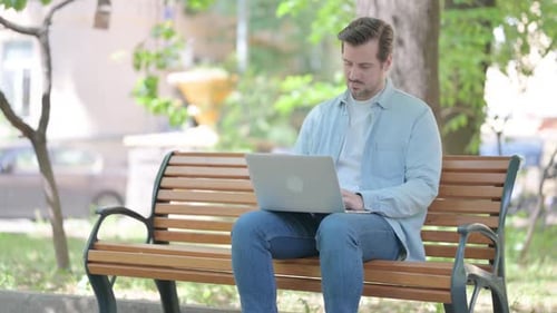 Young Man Working on Laptop Outdoor