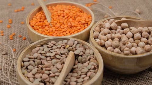 Variety of Raw Legumes in Bowls with Spoons