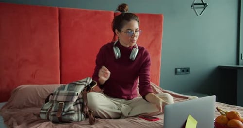 Young Woman Works on Laptop in Bedroom