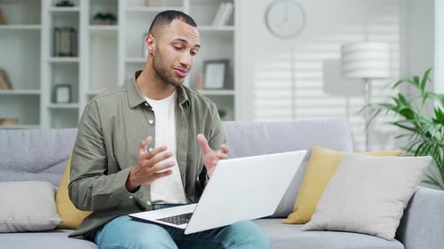 Man Using Laptop for Video Call on Couch